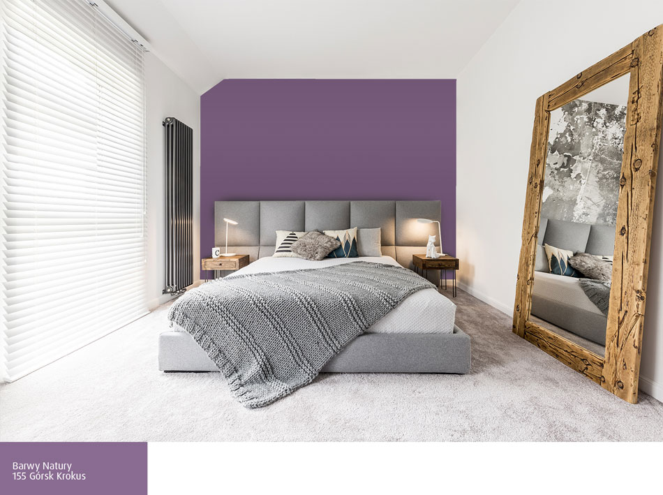 Fioletowa ściana za łóżkiem w szarej sypialni